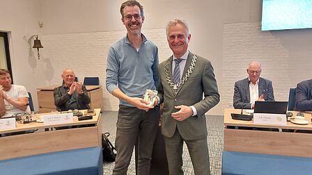 Foto van Matthias Noorlander en burgemeester Metz in de raadzaal
